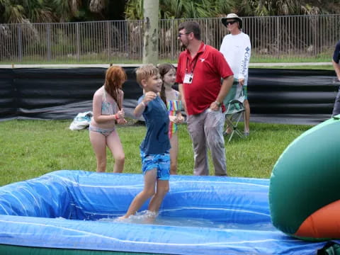 a group of people standing around a pool