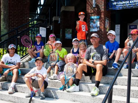 a group of people posing for a photo with tennis rackets