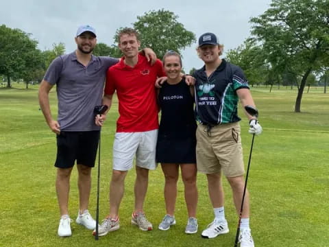 a group of men posing for a picture on a golf course