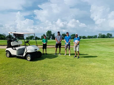 a group of people standing next to a golf cart