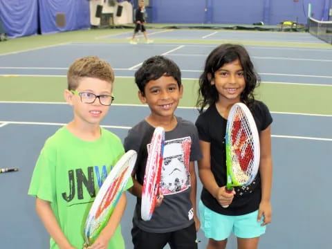 a group of kids holding tennis rackets