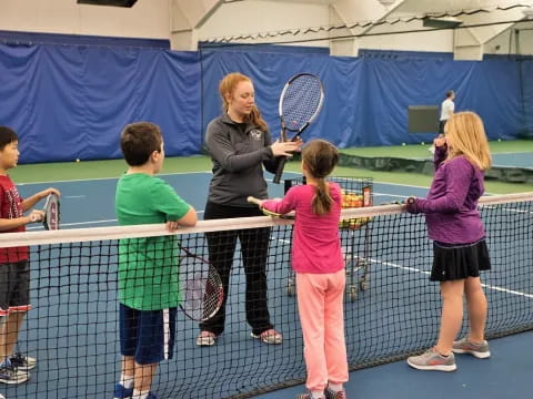 a group of kids playing tennis