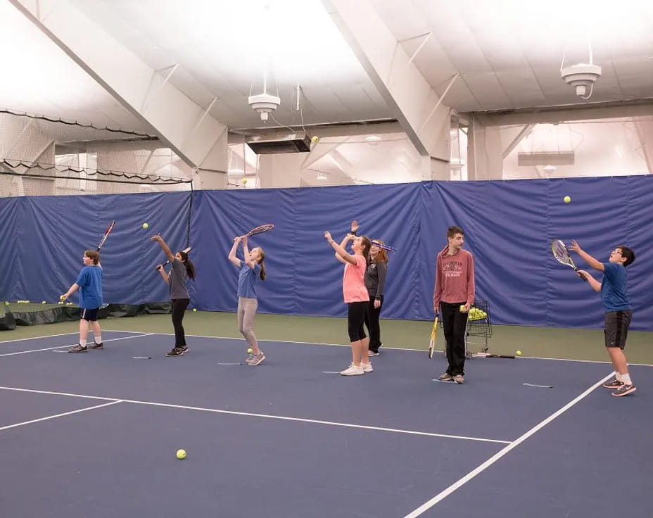 a group of people playing tennis