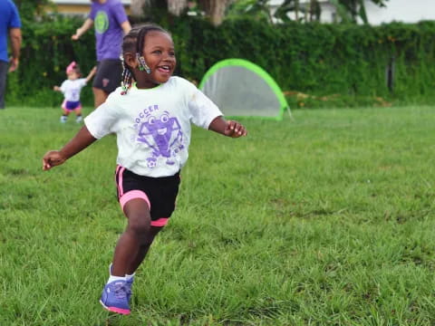 a girl running in a grassy area