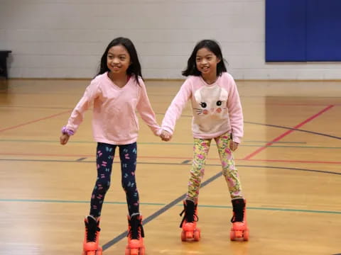 two girls wearing ice skates