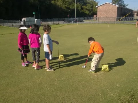 a group of children playing on a golf course