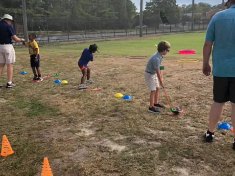 a group of people playing with a stick in a field