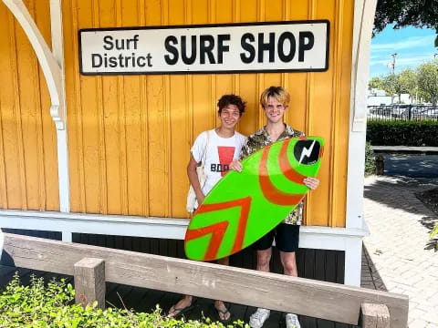 a couple of men holding surfboards