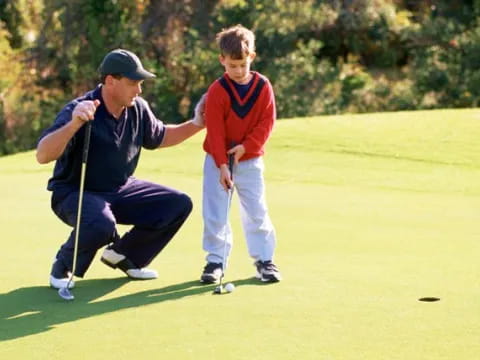 a person and a boy playing golf