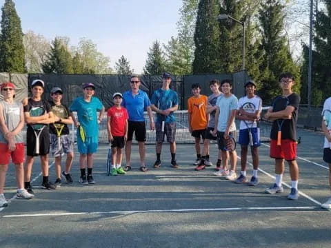 a group of people standing on a tennis court