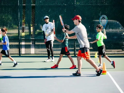 a group of kids playing tennis
