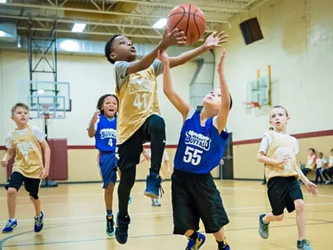 a group of kids playing basketball