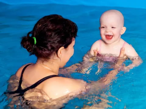 a person and a baby in a pool