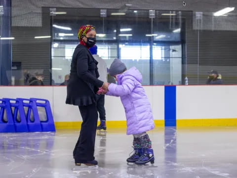 a man and a child on an ice rink
