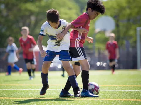 a group of kids compete over a football ball