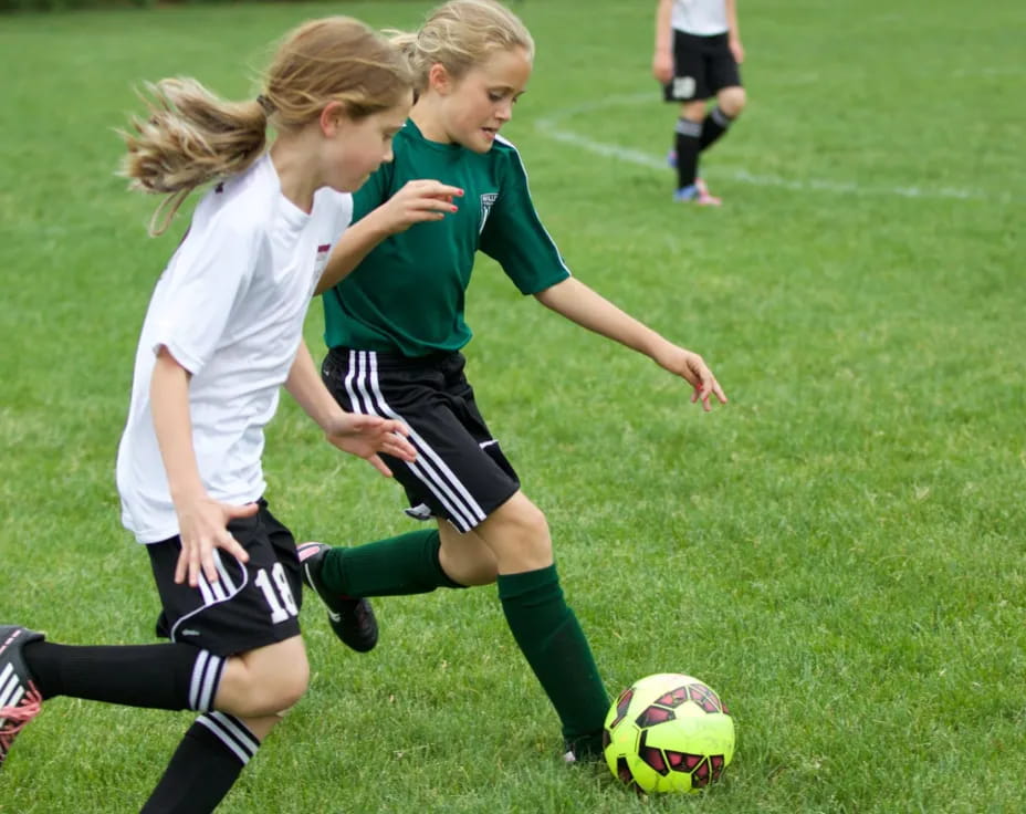 girls playing football on a field