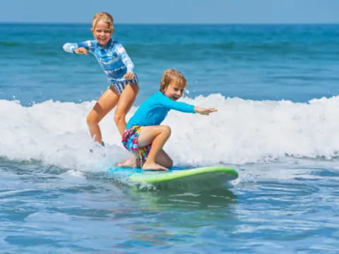 kids on a surfboard in the ocean