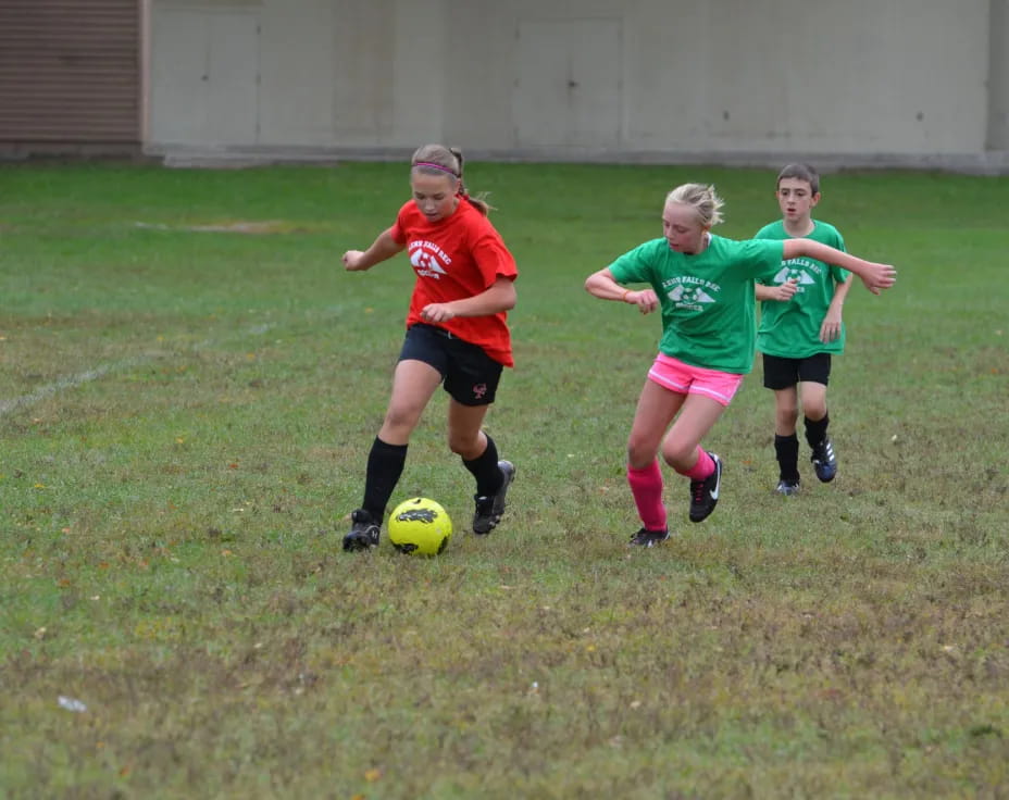girls playing football on a field