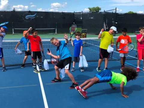 a group of kids playing tennis