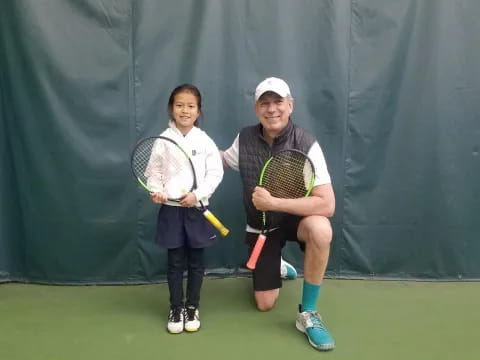 a man and a woman holding tennis rackets