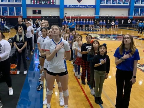 a person in a white shirt and shorts standing in front of a crowd