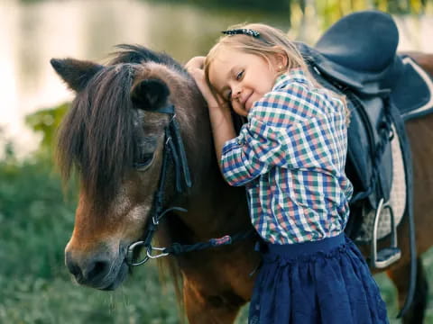 a girl hugging a horse
