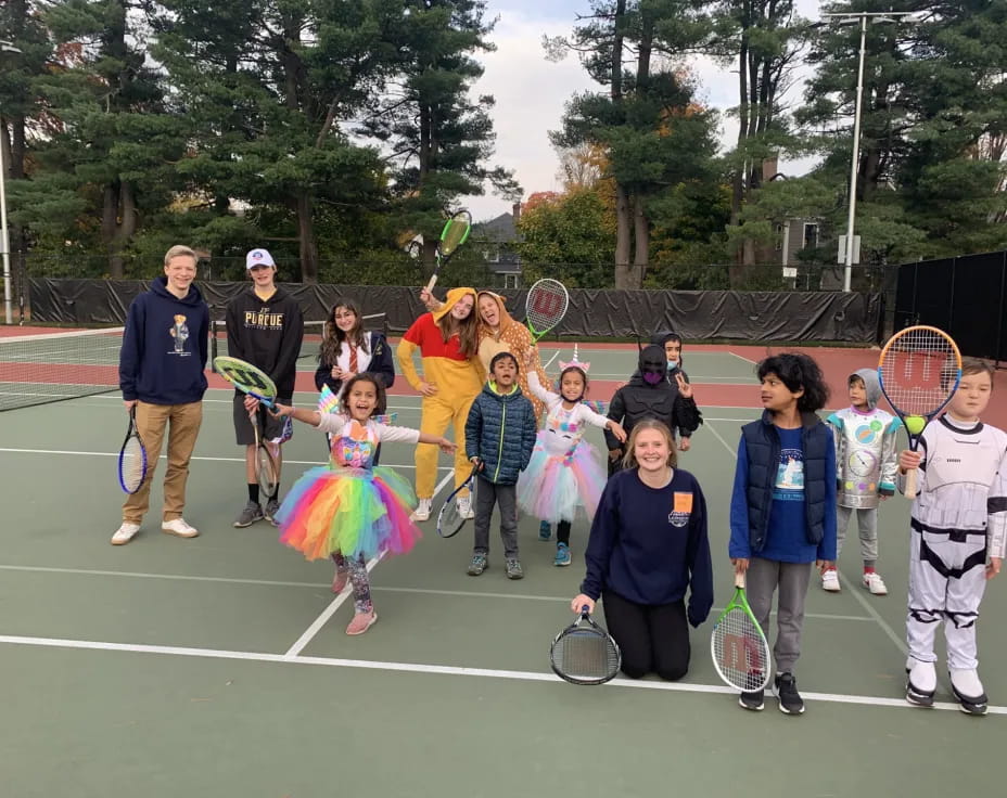 a group of people holding tennis rackets on a tennis court