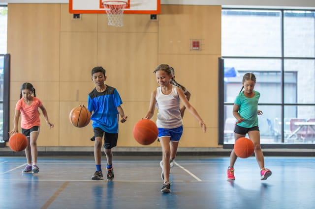 a group of kids playing basketball