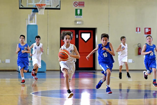 a group of kids playing basketball