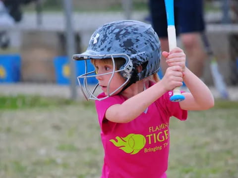 a little girl playing baseball