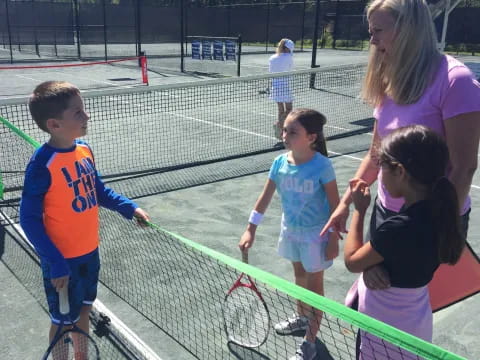 a group of kids playing tennis