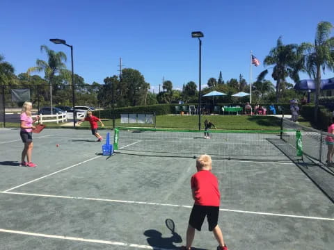 a group of people play tennis