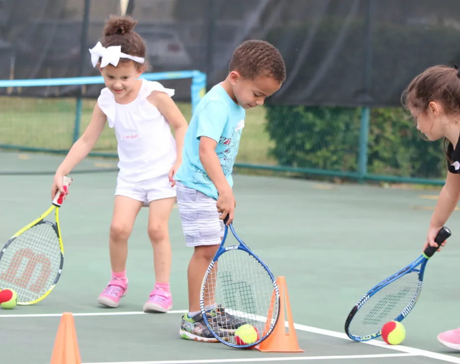 kids playing tennis on a court