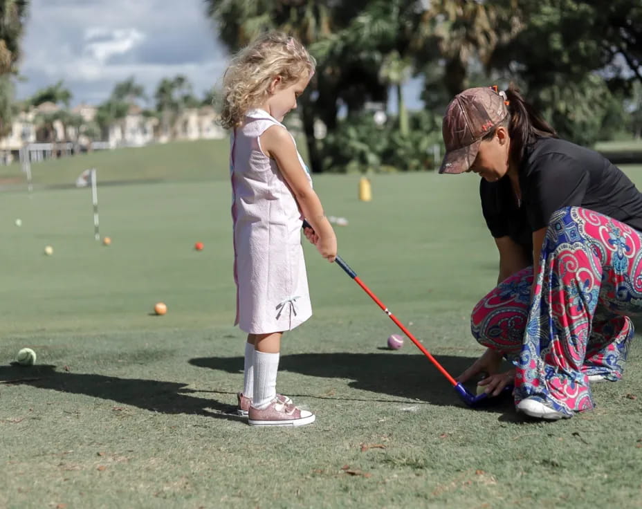 a person and a girl playing golf