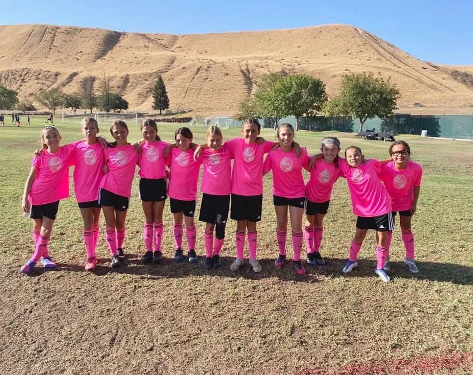 a group of girls in pink shirts