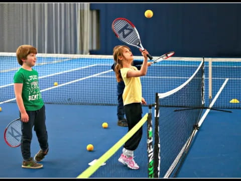 kids playing tennis on a court