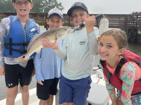 a group of people holding a fish