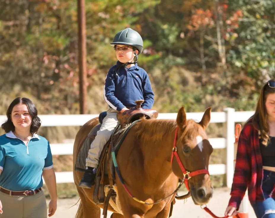 a boy riding a horse