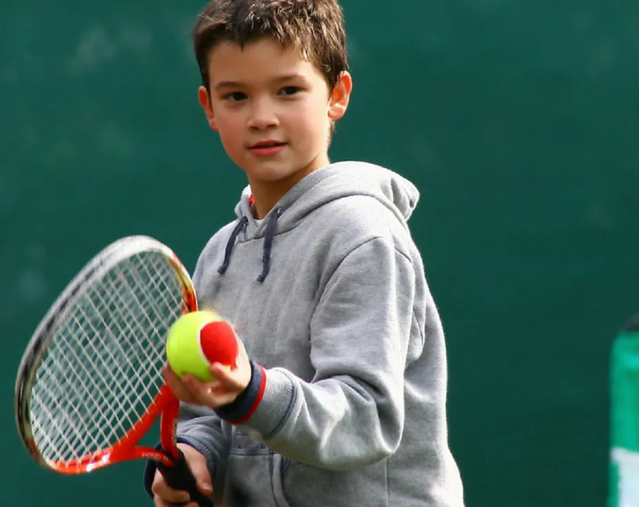 a boy holding a tennis racket