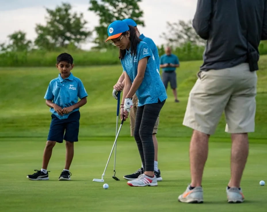 a person and a boy playing golf