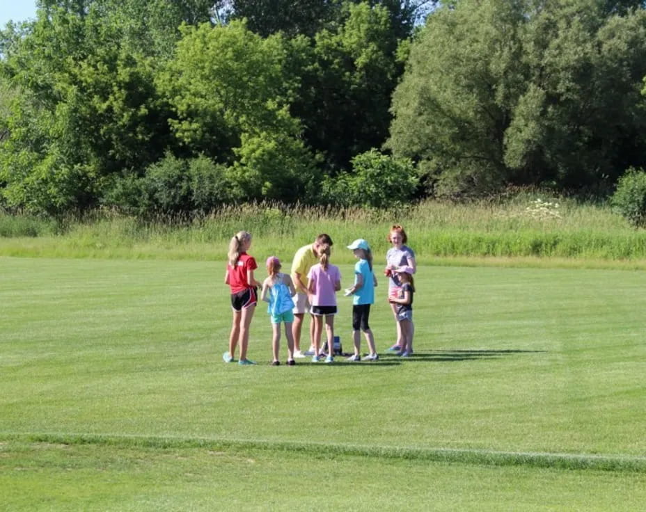 a group of people standing on a grass field