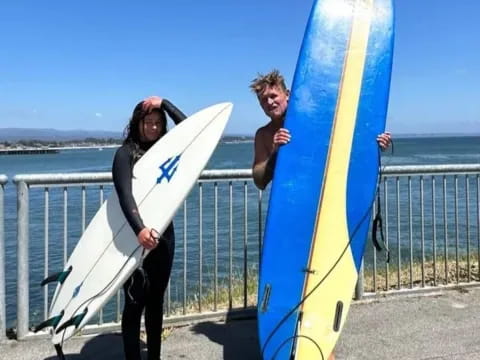 a couple of people holding surfboards