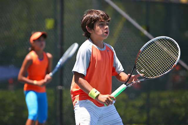 a boy holding a tennis racket