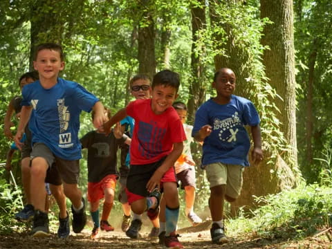 a group of boys running in the woods