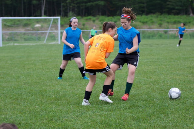 girls playing football on a field
