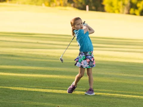 a girl holding a golf club