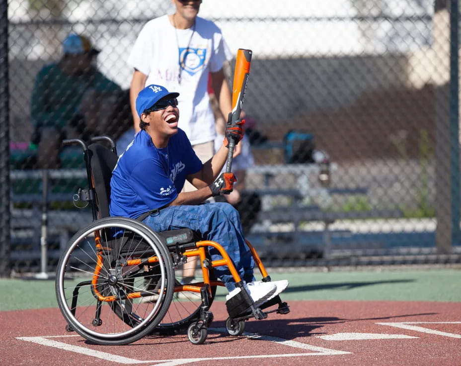 a person in a wheelchair holding a baseball bat