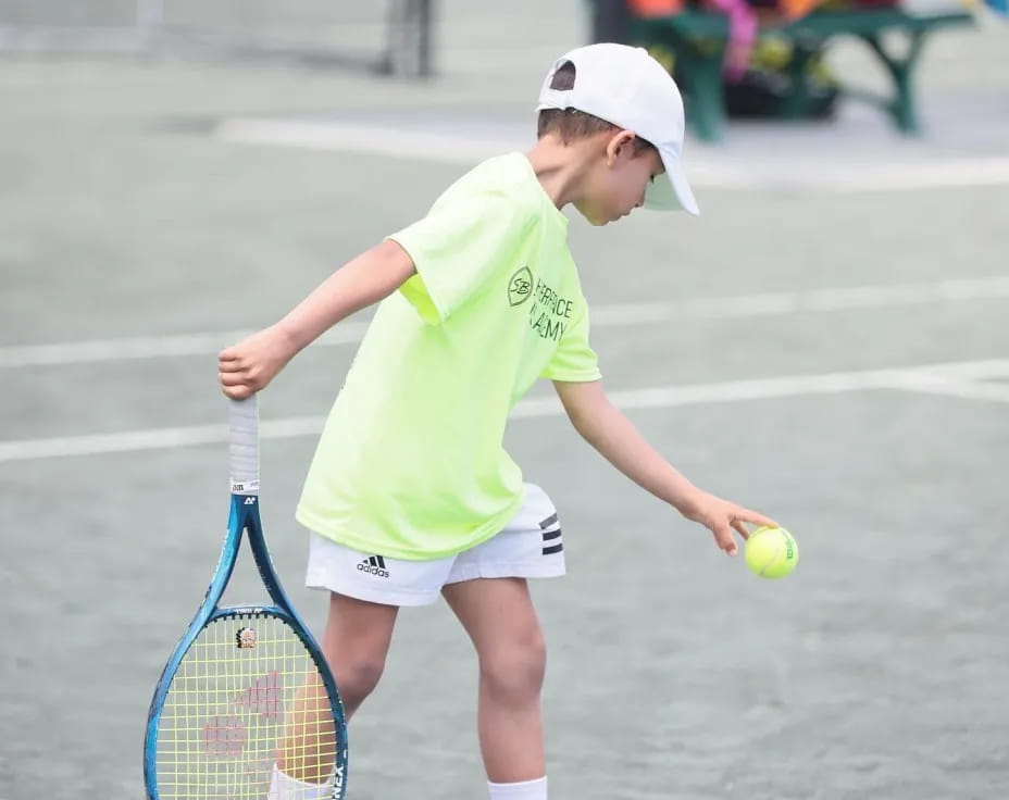 a young boy playing tennis