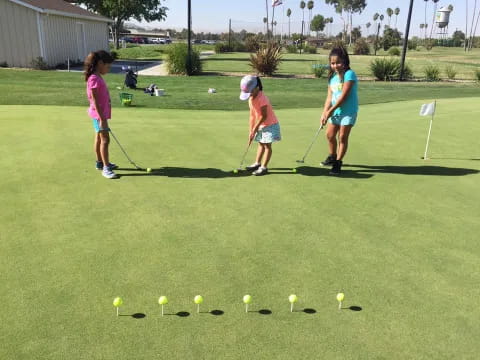 a group of kids playing golf