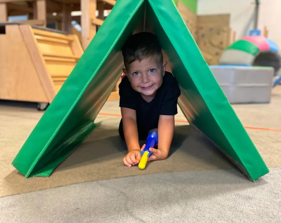 a child in a green tent